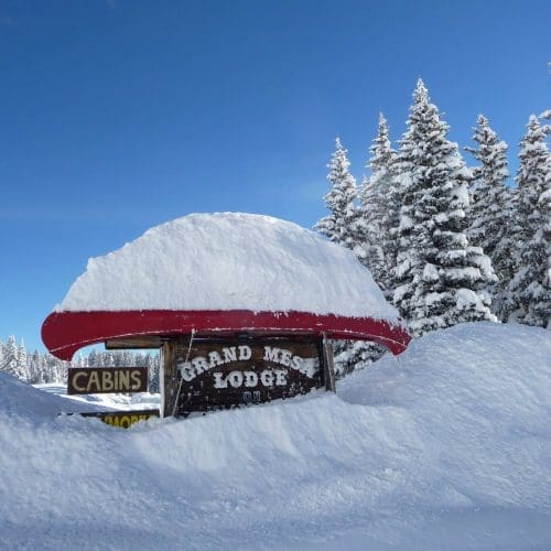 Grand Mesa Lodge Sign with snow drifts on top and surrounding it