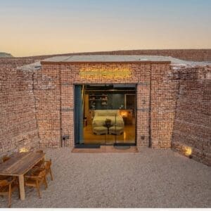 Image of a cave suite with rock and glass, showing an elegant room with a white covered bed