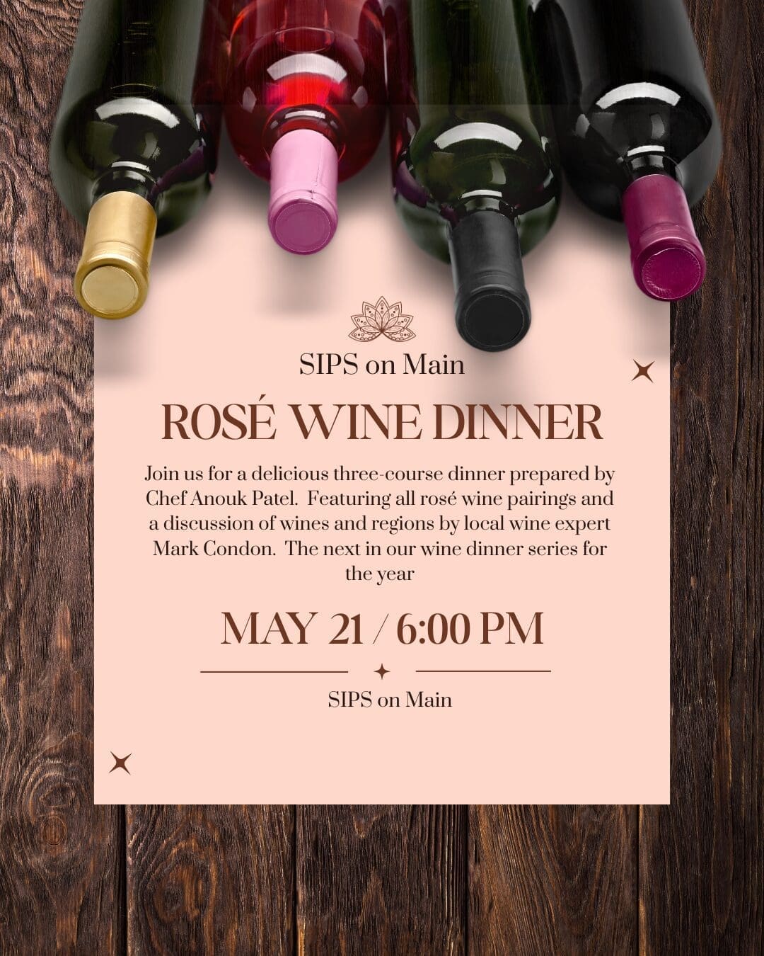 A promotional flyer for the Rosé Wine Dinner at Sips on Main. Visual Composition: Top Section: Four wine bottles with different colored caps (gold, pink, black, and magenta) are lying horizontally against a dark wood-grain background. Main Body: A light pink rectangular paper overlay features the event title "ROSÉ WINE DINNER" in large, elegant brown serif font. Details: The text lists Chef Anouk Patel and wine expert Mark Condon as the evening's hosts, noting a three-course dinner with rosé pairings on May 21 at 6:00 PM. Accents: Small brown starburst icons and a lotus flower logo decorate the corners and center of the invitation.